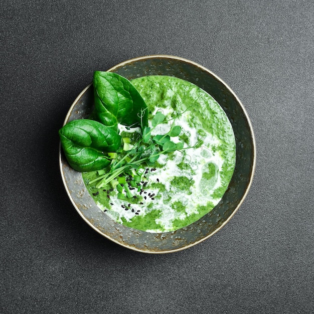 Photo soupe à la crème d'épinards verts avec de la crème dans un bol concept d'alimentation saine de près