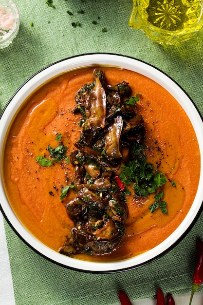 Soupe à la crème de lentilles rouges aux tomates et champignons sauvages frits sur la table. réchauffement végétalien sain pour toute la famille