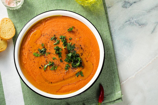 Soupe à la crème de lentilles rouges avec des tomates sur la table des aliments sains et végétaliens pour toute la famille