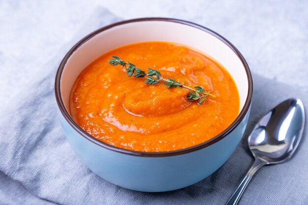 Soupe à la crème de potiron au thym dans un bol