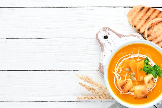 Soupe à la crème de potiron dans un bol, avec du pain grillé. Nourriture diététique. Vue de dessus. Espace de copie gratuit.