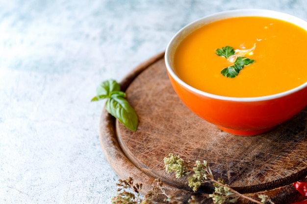 Soupe à la crème de potiron sur surface grise