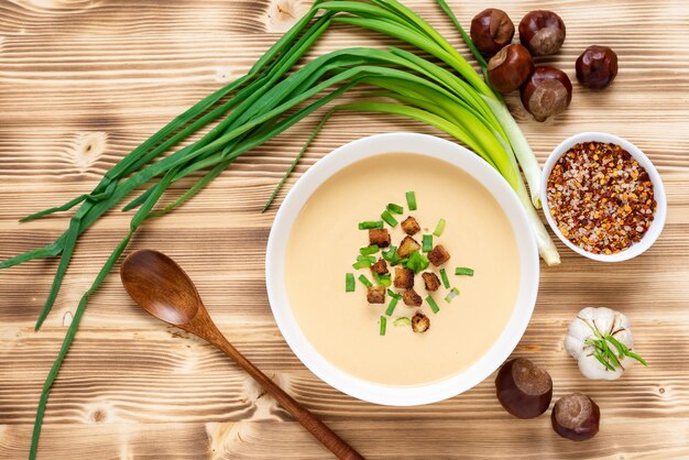 Soupe à la crème traditionnelle de châtaigne sur une table en bois. Vue de dessus.