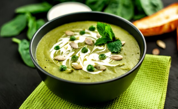Soupe à la crème verte d'épinards et de brocoli. fond de béton ou d'ardoise. Le concept d'une alimentation saine et d'une alimentation saine.
