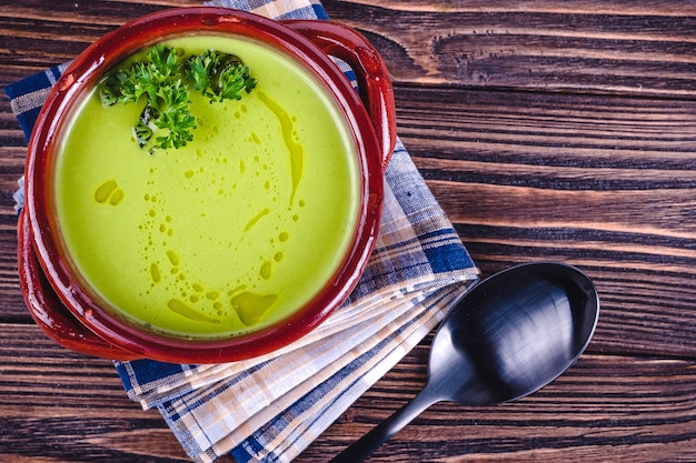 Soupe crémeuse d'asperges fraîches et ingrédients sur table en bois, mise au point sélective