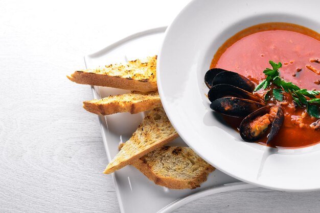 Soupe crémeuse aux tomates et fruits de mer aux moules Sur un fond en bois Vue de dessus Espace libre pour votre texte