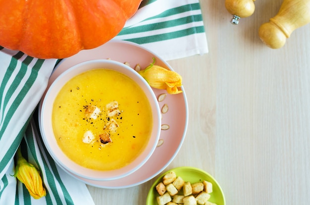 Soupe crémeuse à la citrouille avec graines et croûtons dans un bol.