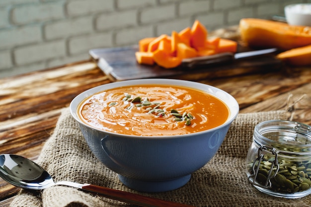 Soupe crémeuse à la citrouille sur une table en bois marron