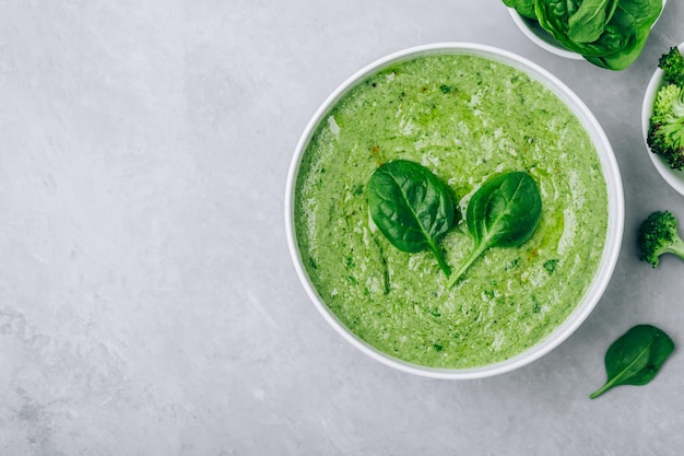 Soupe crémeuse verte aux épinards et au brocoli sur fond de béton gris Alimentation saine et régime alimentaire Vue de dessus