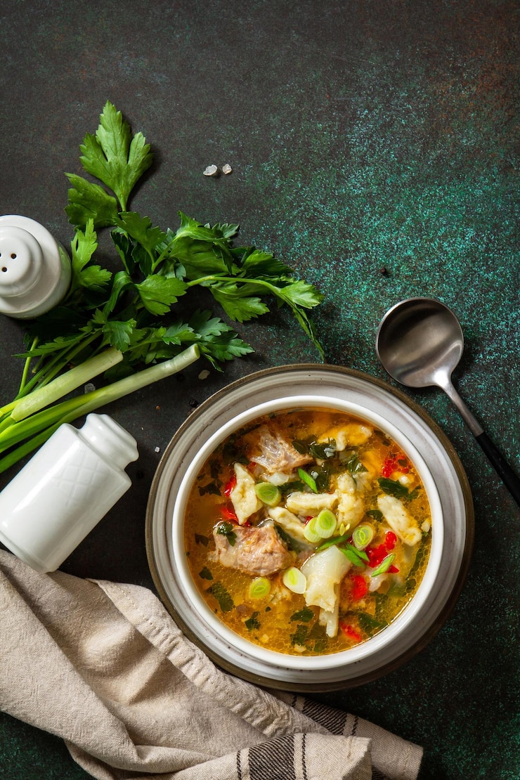 Photo soupe délicieuse de bœuf chaud soupe maison avec des légumes de viande et des gnocchi sur un fond de pierre sombre