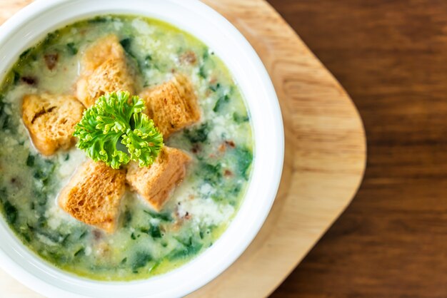 soupe d'épinards avec du pain dans un bol blanc