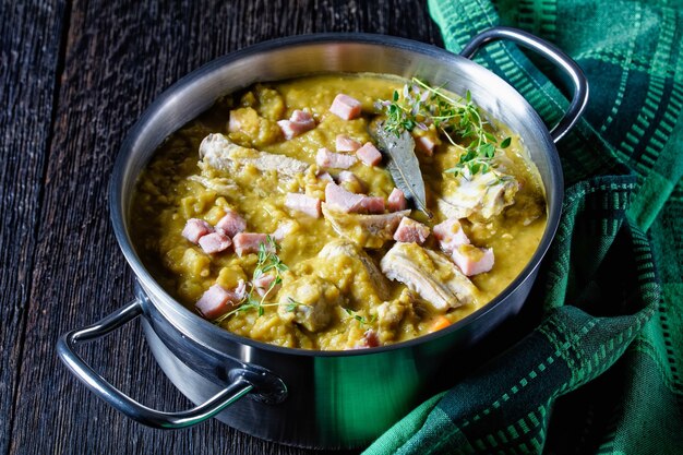 Soupe finlandaise aux pois verts avec côtes de porc et jambon dans une casserole, vue horizontale d'en haut, gros plan