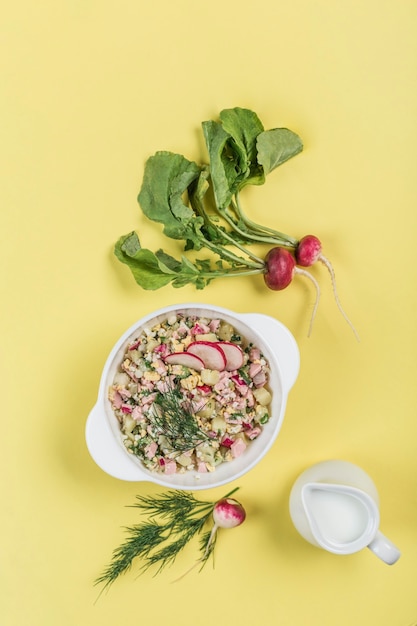 Soupe froide au yogourt d'été avec œuf, concombre, saucisse et aneth dans une assiette