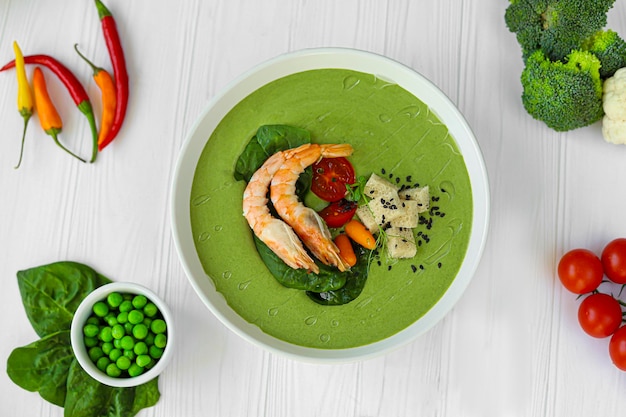 Soupe de fruits de mer avec des épinards et des croutons, des champignons décorés de crevettes.