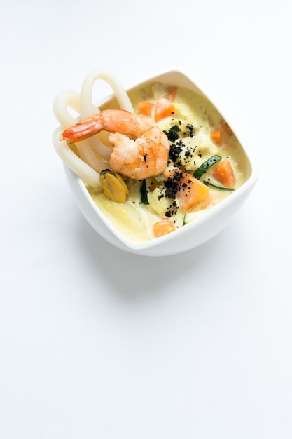 Soupe de fruits de mer sur une surface blanche