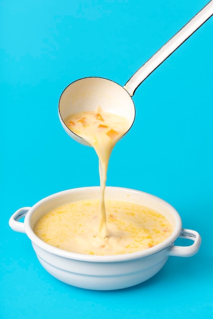 Photo soupe grecque dans un bol en émail blanc verser la soupe à la louche