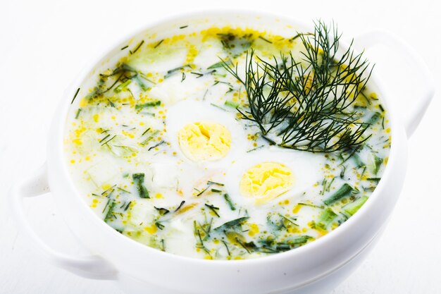 Soupe de hachis de printemps dans un bol blanc sur la serviette verte