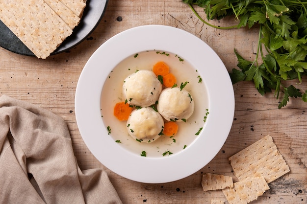 Soupe juive traditionnelle de boule de matsa et pain de matsa sur la table en bois