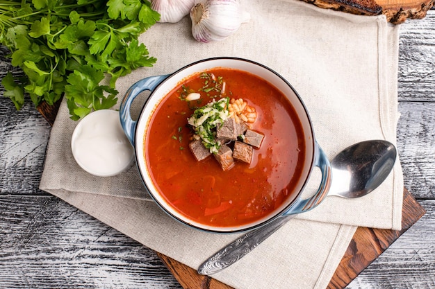 Soupe Kharcho Kharcho avec de la viande sur un fond blanc en bois