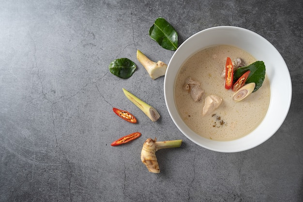 Soupe de lait de coco au poulet (Tom Kha Gai) sur fond sombre, cuisine locale thaïlandaise