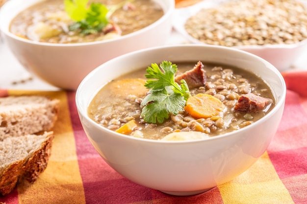 Soupe de lentilles aux morceaux de cou de porc fumé, carottes, pommes de terre et coriandre. Cuisine traditionnelle slovaque, tchèque ou d'Europe de l'Est.