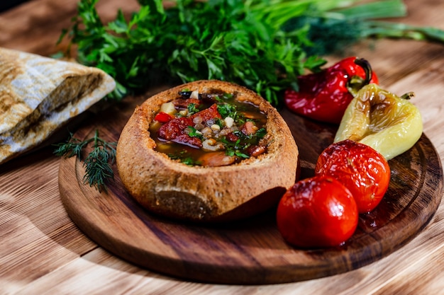 Soupe de lentilles avec côtes de porc fumées dans une assiette de pain