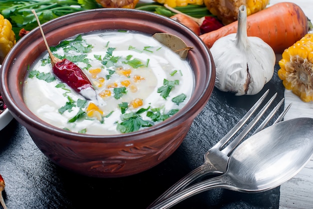 Soupe de maïs dans une assiette en céramique et ingrédients