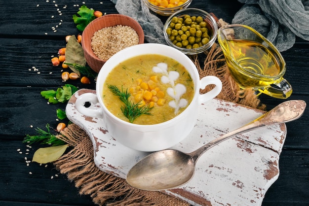 Soupe de maïs avec des légumes frais dans un bol Aliments sains Sur un fond en bois noir Vue de dessus Copiez l'espace pour votre texte