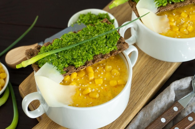 Soupe de maïs avec pate d'ail frais dans un bol blanc Nourriture saine sur fond de bois Cuisine végétalienne