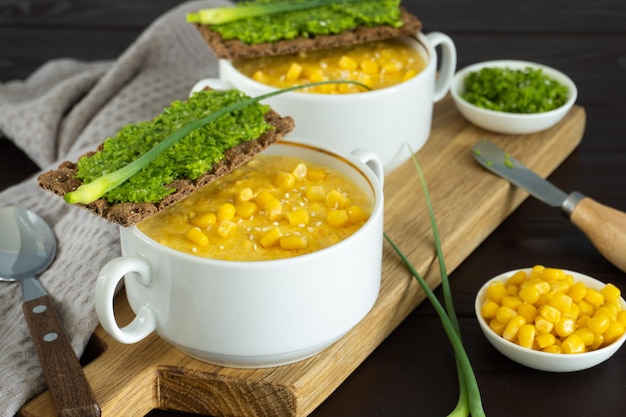 Soupe de maïs avec pate d'ail frais dans un bol blanc Nourriture saine sur fond de bois Cuisine végétalienne