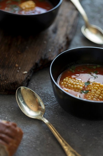 Soupe de maïs et de tomates à l'américaine sur une table rustique avec du pain de seigle