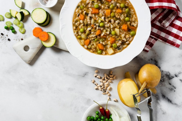 Soupe minestrone italienne aux légumes et haricots sur une table en marbre blanc