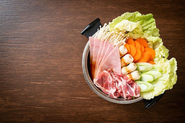 Soupe noire sukiyaki ou shabu hot pot avec de la viande crue et des légumes