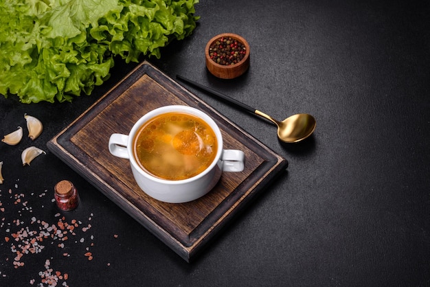 Soupe de nouilles au poulet avec persil et légumes dans une assiette blanche