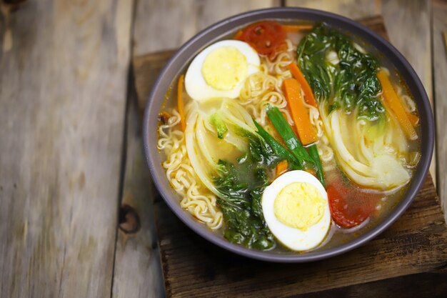 Soupe de nouilles aux oeufs et chou bok choy dans un bol.