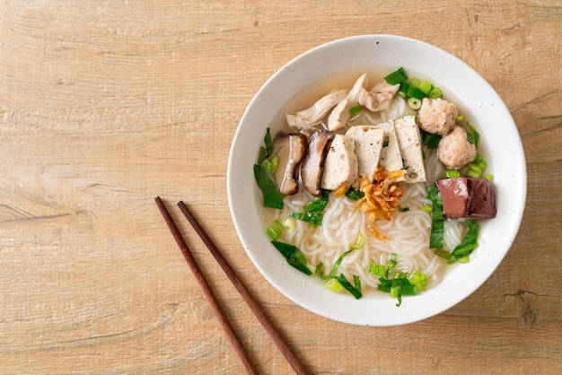 Soupe de nouilles de riz vietnamiennes avec saucisse vietnamienne servie de légumes et d'oignons croustillants - style de cuisine asiatique