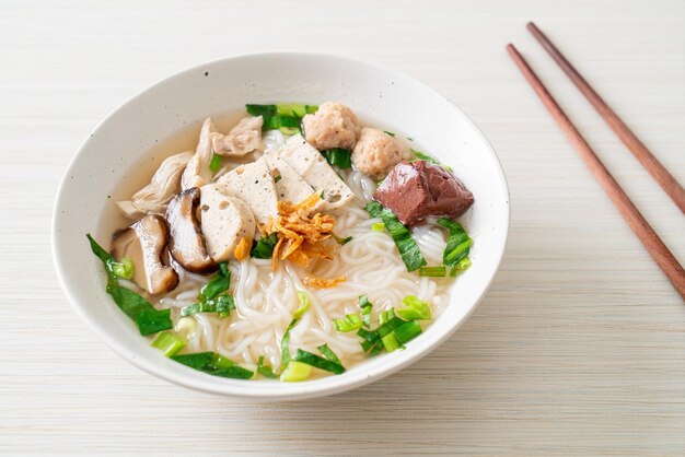 Soupe de nouilles de riz vietnamiennes avec saucisse vietnamienne servie de légumes et d'oignons croustillants - style de cuisine asiatique