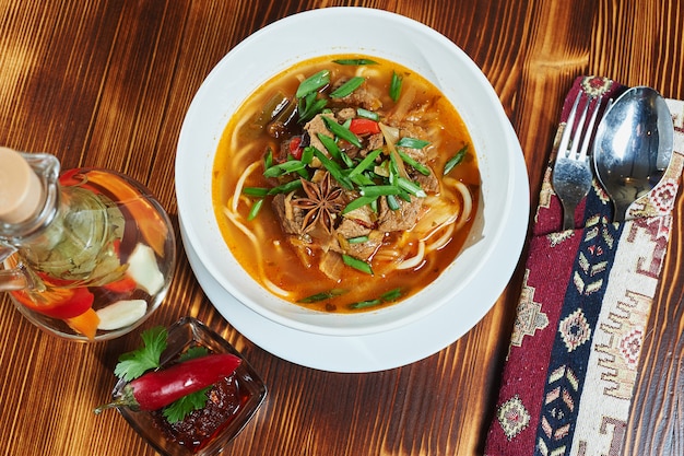 Soupe orientale ouzbek Lagman sur une table en bois.