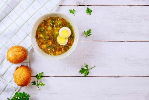 Soupe à l'oseille saine avec œuf et petits pains croustillants