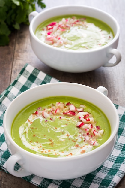 Soupe de pois aux radis sur table en bois rustique