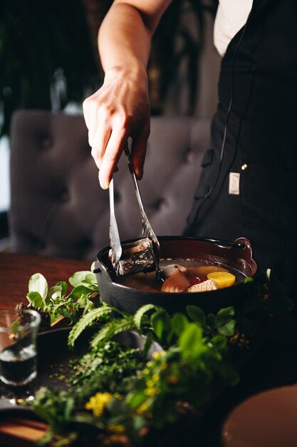 Soupe de poisson traditionnelle russe dans un bol ukha servi avec de la braise et de la vodka sur planche de bois Bouillon de poisson Cuisine traditionnelle en Russie