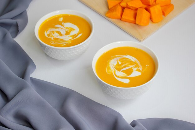 Soupe de potiron blanche avec tissu gris et tranches de courge musquée