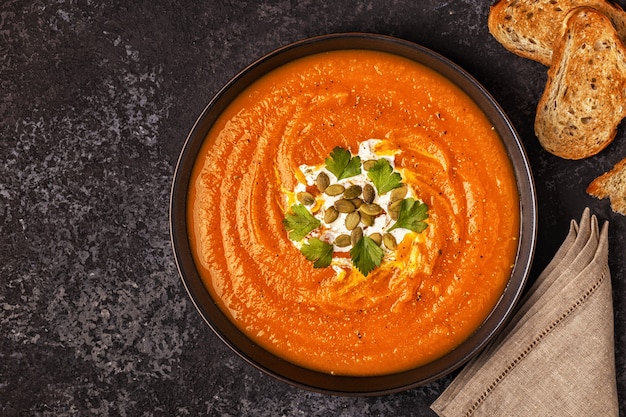 Soupe de potiron et carotte à la crème, graines et persil