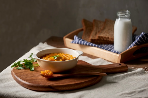 Soupe de potiron et carottes rôties avec crème et pain grillé sur table en bois. Espace de copie