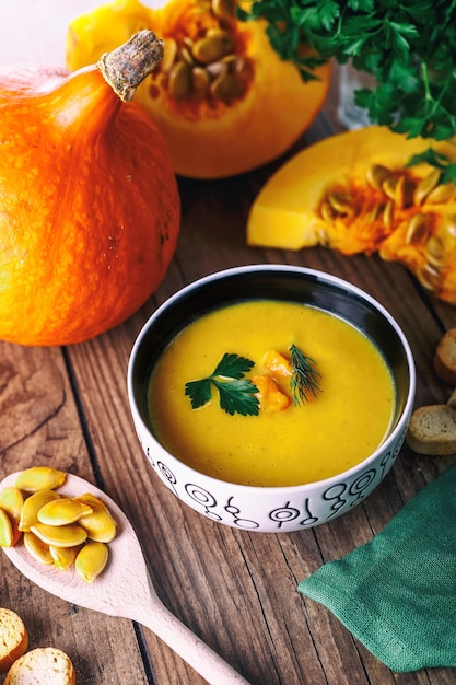 Photo soupe de potiron à la crème avec des herbes fraîches et des craquelins sur fond de bois foncé aliments sains sélectif fo