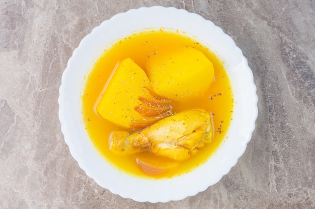 Soupe de poulet dans un bol, sur le marbre.