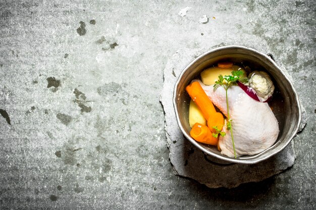 Soupe de poulet dans une vieille casserole avec des légumes.