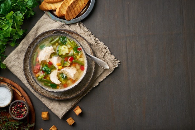 Soupe de poulet maison aux légumes, brocoli sur un brun foncé