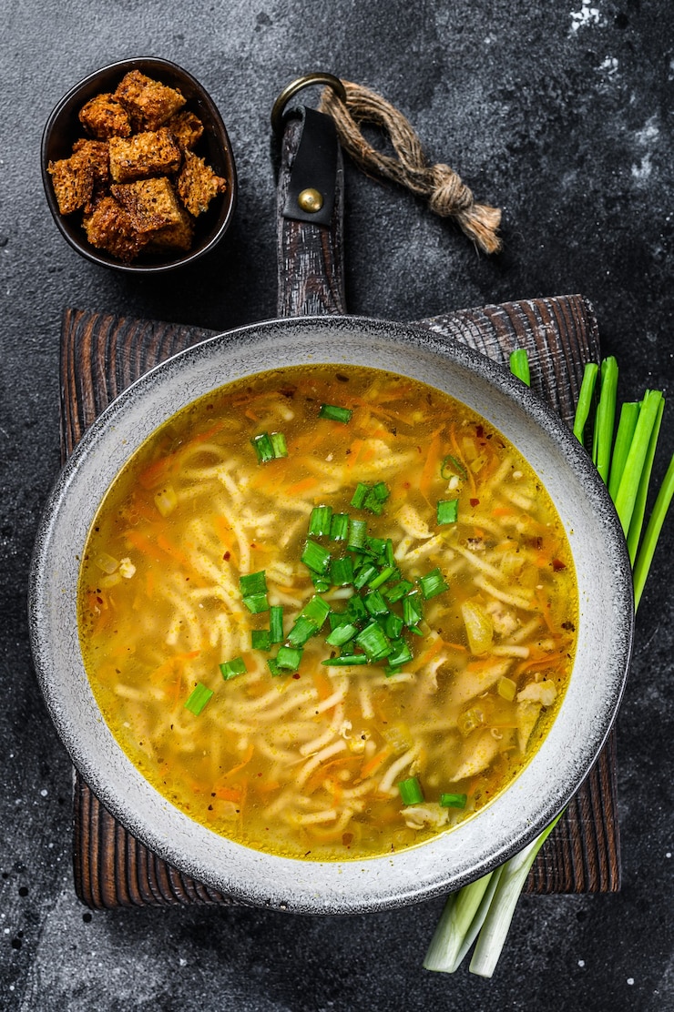 Photo soupe de poulet maison fraîche avec des nouilles à table. vue de dessus.