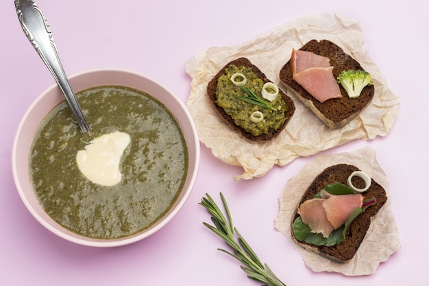 Soupe de purée de brocoli aux légumes dans un bol blanc et sandwichs